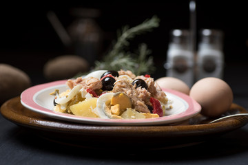 Potato salad with olives, tuna, boiled egg and its dressing. Delicious plate of Spanish food