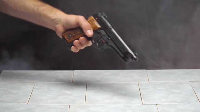 Purchasing Handgun with Stack of Money Across Countertop in Smokey Room