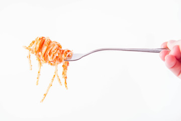 Spaghetti bolognese on a fork helb by a woman's hand on a white background
