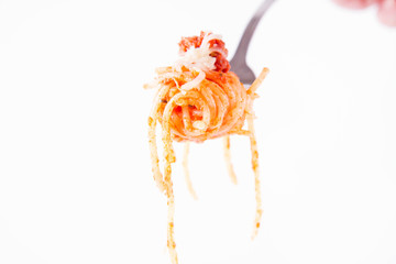 Spaghetti bolognese sprinkled with cheese on a fork on a white background