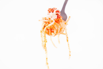 Spaghetti bolognese sprinkled with cheese on a fork on a white background