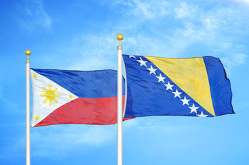 Philippines and Bosnia and Herzegovina two flags on flagpoles and blue cloudy sky
