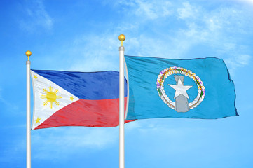 Philippines and Northern Mariana Islands two flags on flagpoles and blue cloudy sky