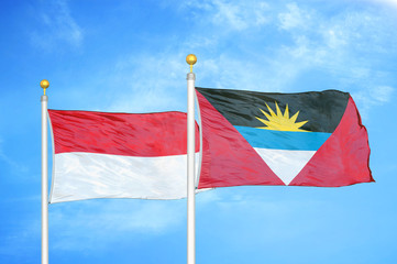 Indonesia and Antigua and Barbuda two flags on flagpoles and blue cloudy sky