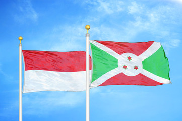 Indonesia and Burundi two flags on flagpoles and blue cloudy sky