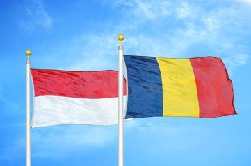 Indonesia and Chad two flags on flagpoles and blue cloudy sky