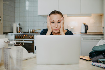 Überforderte Frau beim Home-Office in der Küche