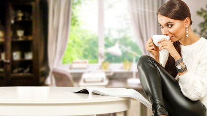Slim young woman with cup of coffee or tea and white wooden table in home interior with window 