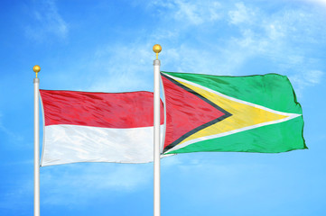Naklejka na ściany i meble Indonesia and Guyana two flags on flagpoles and blue cloudy sky