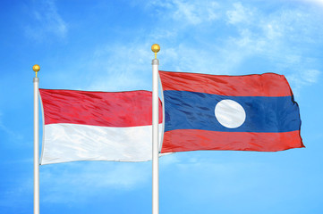Indonesia and Laos two flags on flagpoles and blue cloudy sky