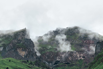 Green mountains covered in wet rain clouds