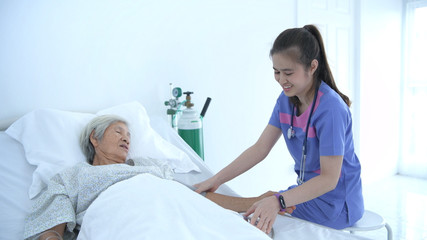 Fototapeta na wymiar Medical concepts. Young nurse measuring the pressure of elderly patients in the hospital. 4k Resolution.