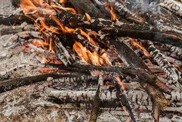 Burning coals in a fire with orange flames. Ashes.