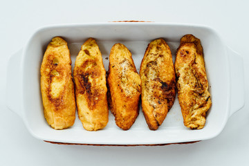 Torrijas, typical Spanish sweet fried toasts of sliced bread soaked in eggs and milk on tray isolated on white background