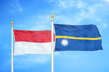 Indonesia and Nauru two flags on flagpoles and blue cloudy sky