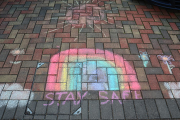 A beautiful rainbow drew by children on the street during the covid-19 quarantine. Kids are drawn....