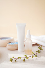 Fototapeta na wymiar spa skin care - serum and tube with face cream on a background of bowls with different components