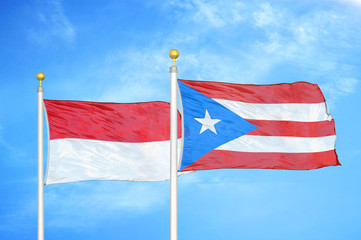Indonesia and Puerto Rico two flags on flagpoles and blue cloudy sky