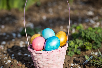 Pink easter basket with eggs on a background of green grass.