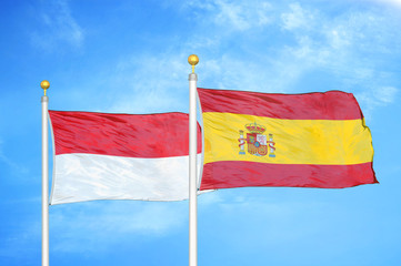 Indonesia and Spain two flags on flagpoles and blue cloudy sky