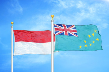 Indonesia and Tuvalu two flags on flagpoles and blue cloudy sky