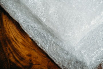 Obraz premium Setting of the delivery box for the customer, online sales, plastic bubbles on wooden table. Online shopping concepts.