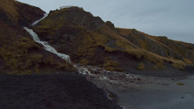 A Running Current River Down to the Clean Lake Surrounded by the Rocky Mountains at Iceland- Wide Shot