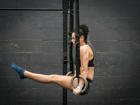 Exercising woman holding gymnast rings