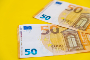 Euro banknotes on a yellow background. Copy, empty space for text