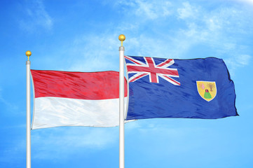 Indonesia and Turks and Caicos Islands two flags on flagpoles and blue cloudy sky