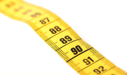 Close-up of a yellow measuring tape isolated on white - 90