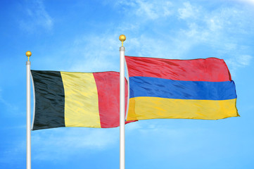 Belgium and Armenia two flags on flagpoles and blue cloudy sky