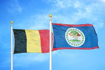 Belgium and Belize two flags on flagpoles and blue cloudy sky
