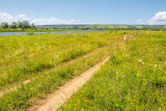 country road in the meadow, valley between the hills