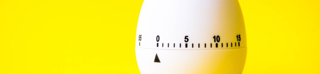 white egg timer on yellow background. Happy Easter in the kitchen. Home related, home staying. Free copy space. banner