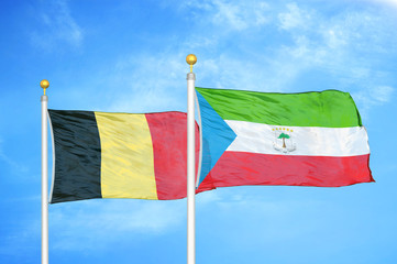 Belgium and Equatorial Guinea two flags on flagpoles and blue cloudy sky