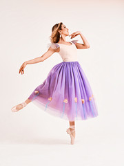 Naklejka premium Ballet dancer or classic ballerina dancing isolated on white studio background. Woman with the violet cloth. The dance, grace, artist, contemporary, movement, action and motion concept