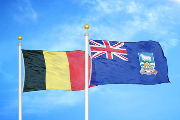 Belgium and Falkland Islands two flags on flagpoles and blue cloudy sky