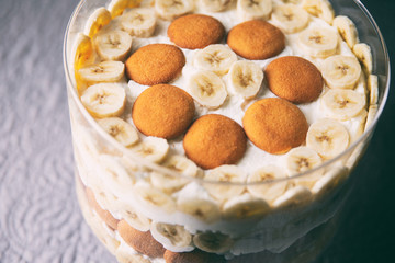 Banana pudding, popular in the Southern United States, made with vanilla wafer cookies, pudding, whipped cream, and banana slices. Shown in a trifle bowl. 