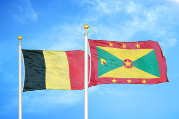 Belgium and Grenada two flags on flagpoles and blue cloudy sky