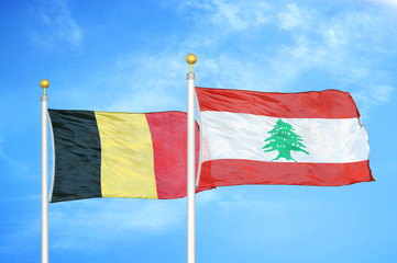 Belgium and Lebanon two flags on flagpoles and blue cloudy sky