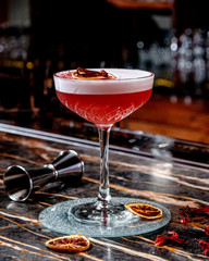red cocktail with cinnamon sticks
