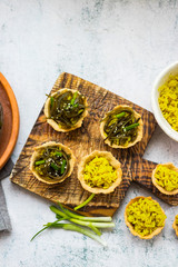 Vegan tarts with long rice filling and stuffed with laminaria kelp seaweed salad. Healthy snack.