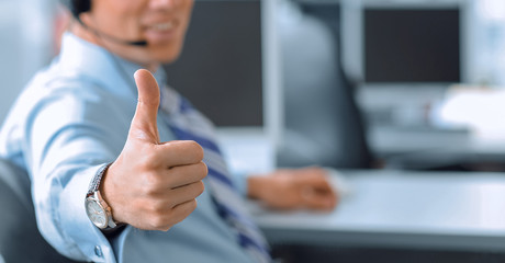 Happy male in headphones gesturing thumb up