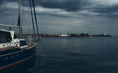 sailing yacht moored in a bay with a lighthouse