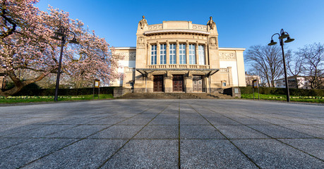 Stadttheater Gießen im Frühling mit blühendem Magnolienbaum