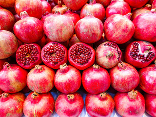 Ripe red pomegranates are displayed in a row. Fruit background.