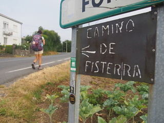 Pilgrim and Iron sign board written "CAMINO DE FISTERRA", Camino de Santiago, Way of St. James, Journey from Negreira to Santa Marina, Fisterra-Muxia way, Spain