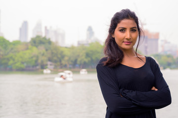 Fototapeta premium Young beautiful Persian woman with arms crossed at the park
