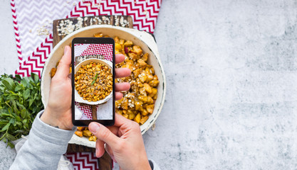 Picture of food, making phone screen photo of sweet baked apples, fruits - vegan breakfast dessert. Smartphone photography of vegetarian meal. Blogging style.